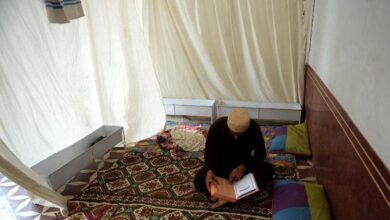 أحد الباكستانيين في مكان اعتكافه وهو يتلو آيات من القرآن الكريم